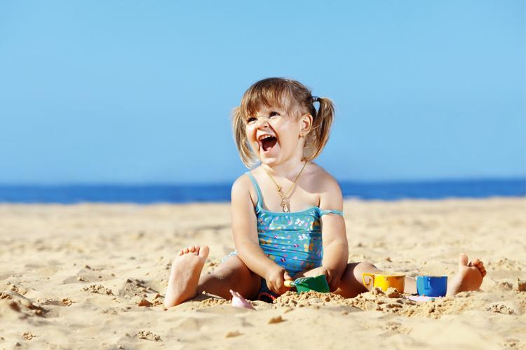 criança brincando na praia