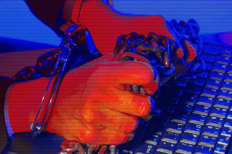 homem digitando com as mãos presas no computador