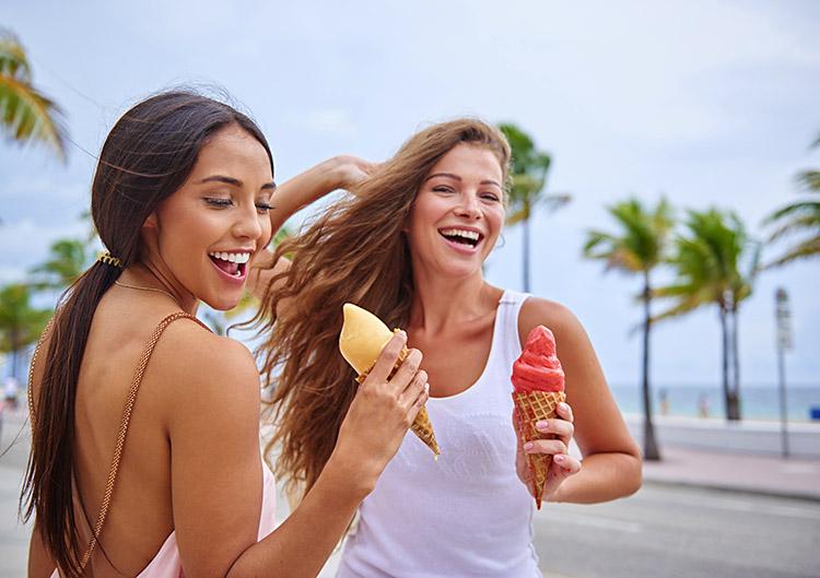 duas meninas sorrindo e tomando sorvete, aproveite o final de semana