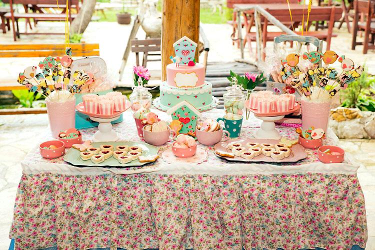 Mesa de festa de aniversário decorada com bolo e doces.
