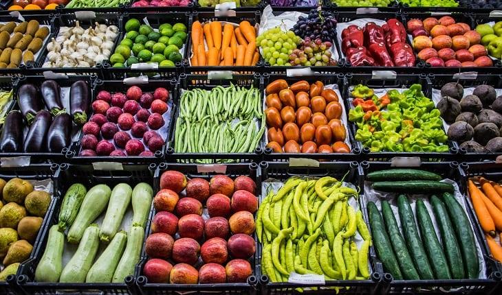 frutas e vegetais diversos em caixas pretas expostos no supermercado