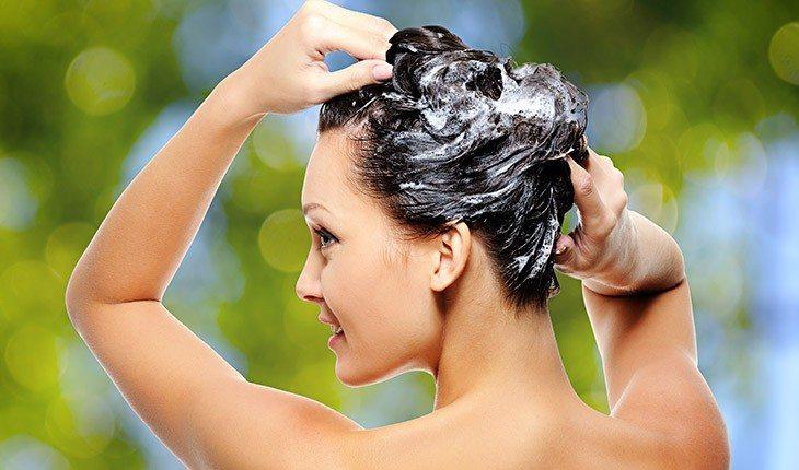 Na foto há uma mulher com creme hidratante nos cabelos