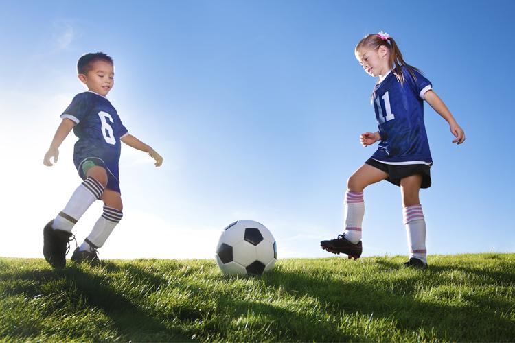 menino e menina jogando futebol