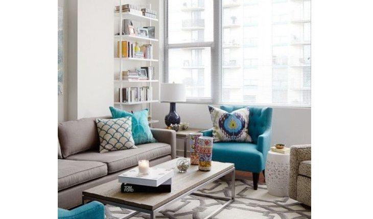 Sala com sofá cinza e almofadas e vede-água ou com estampas dessa cor