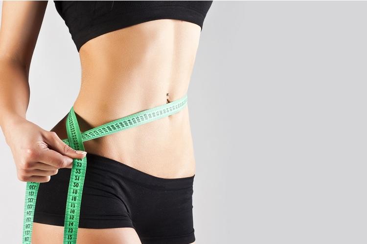 pense magro: mulher medindo cintura com fita métrica