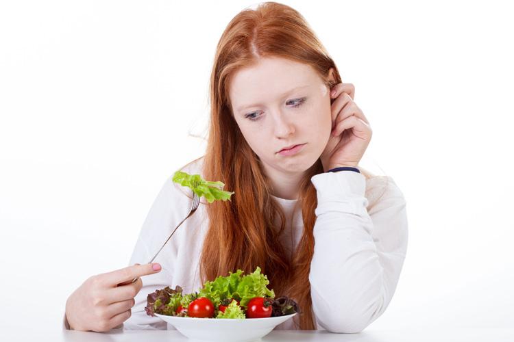mulher triste comendo salada