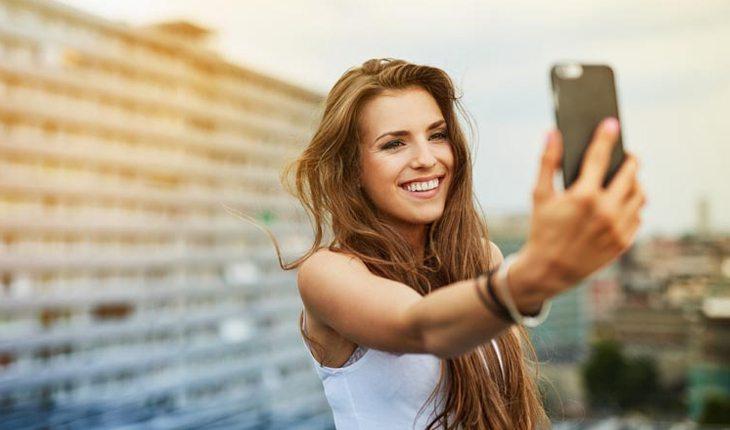 mulher de cabelo comprido tirando uma selfie