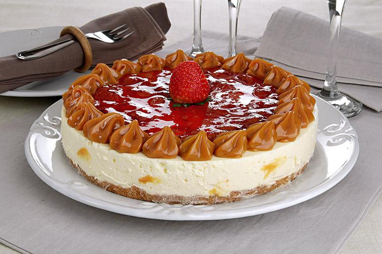 Cheesecake de morango com doce de Leite em um prato de servir branco.