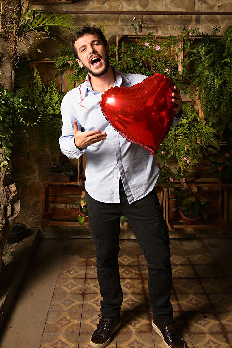 Jayme Matarazzo na coletiva de imprensa da novela Haja Coração segurando um balão de coração na mão