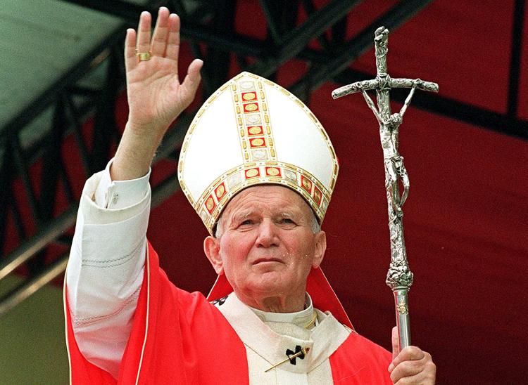 Foto de João Paulo II, com as vestes branca e vermelha de papa, segurando um crucifixo