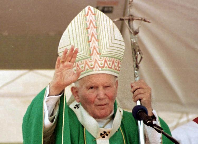 papa João Paulo II de roupa verde com a mão para cima 
