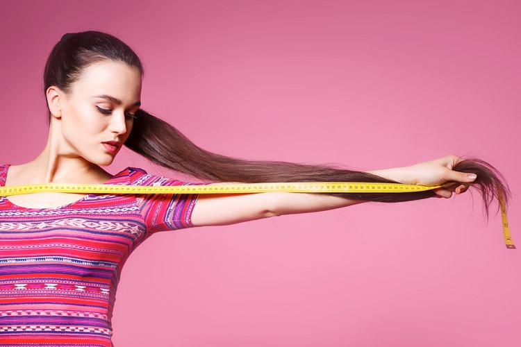 Mulher medindo os fios para o cabelo crescer mais rápido