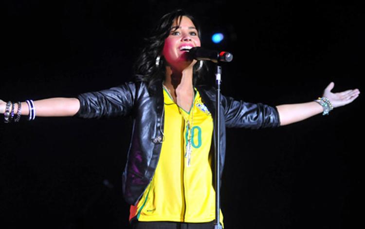 Demi Lovato cantando com a camisa do Brasil
