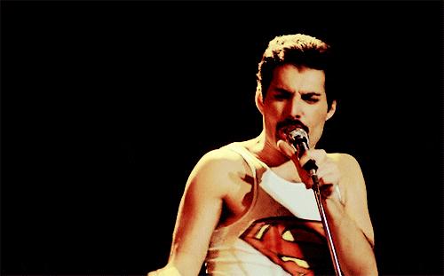 gif do canto freddie mercury com uma roupa de superman cantando