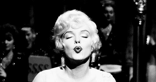 a atriz marilyn monroe mandando beijo em preto e branco