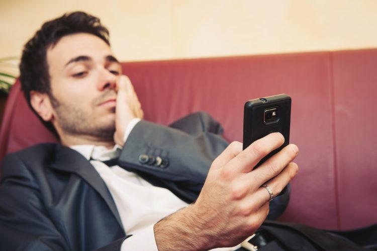 Homem, sentado no sofá, mexendo no celular, smartphone android, duvidas