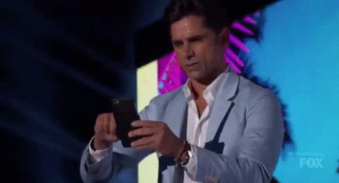 homem usando o celular parece jogar várias pokébolas