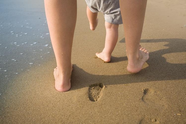 pernas de mãe e filho na praia