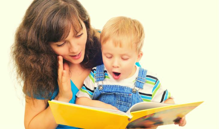 mãe lendo livro para o filho sorrindo