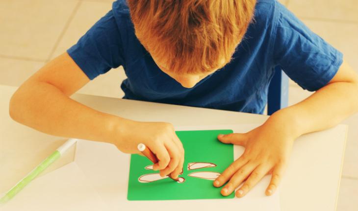 menino desenhando na mesa