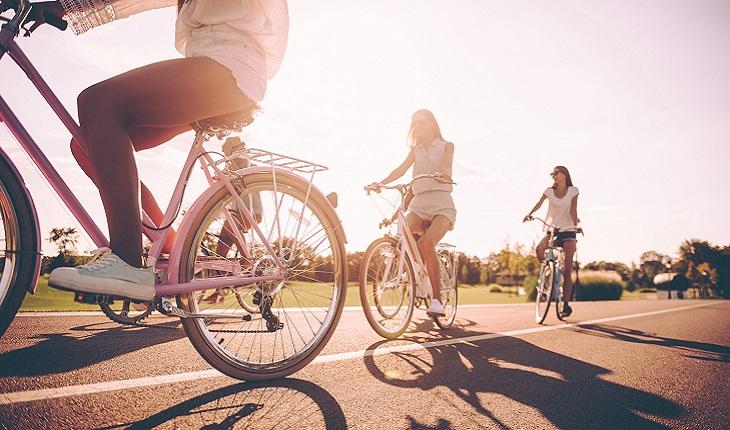 A foto mostra tr~es mulheres andando de bicicleta para manter para manter o cérebro jovem