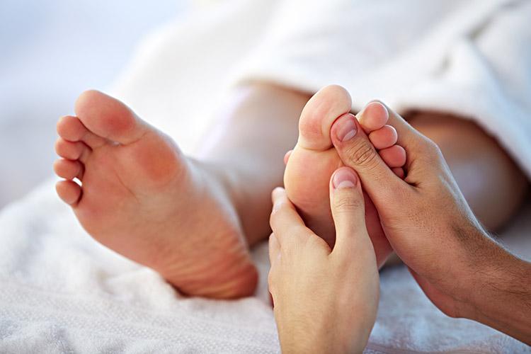 mulher massageando os pés 