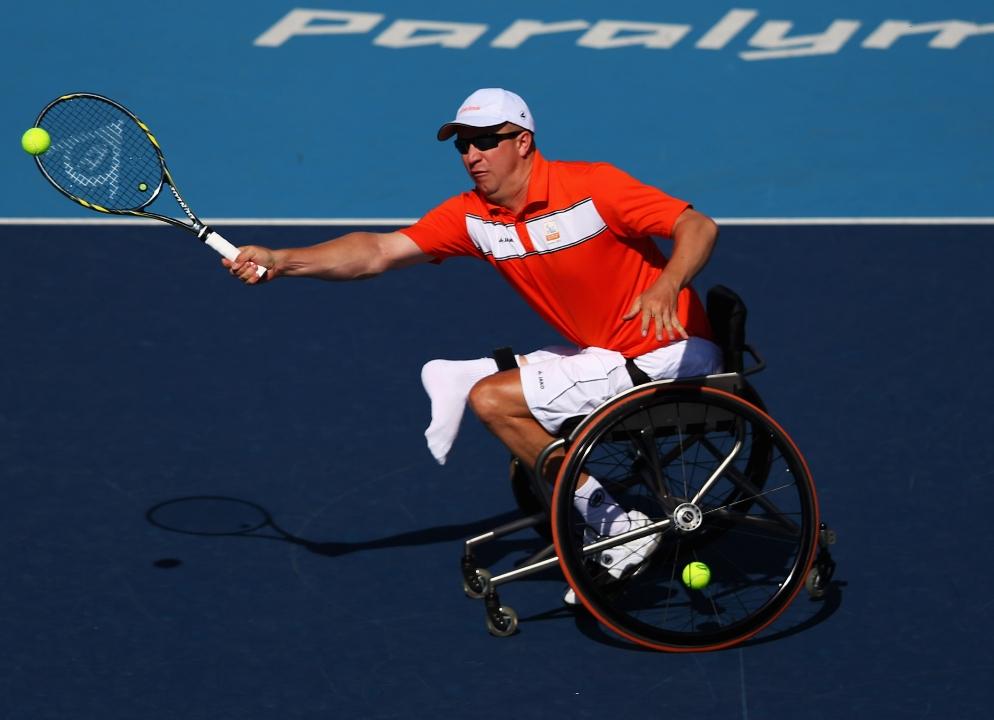 Jogador de Tênis em cadeira de rodas rebatendo a bola