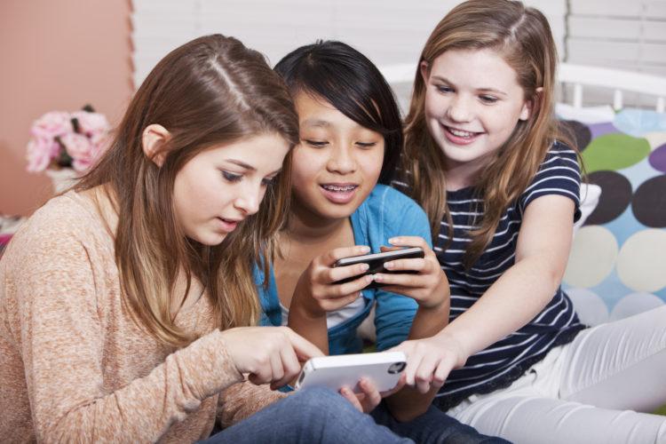 tres-amigas-adolescentes-sorrindo-digitando-mensagens-celular-smartphone