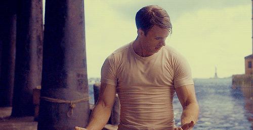 o ator chris evans, o capitão américa, de camiseta branca olhando os musculos, força 