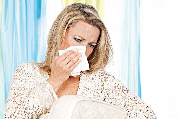 Mulher com alergia virando o colchão