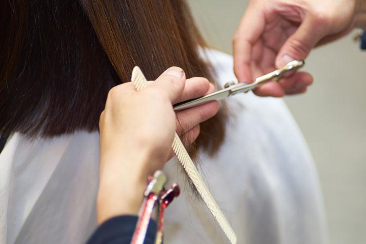 Cabeleireiro cortando as pontas do cabelo perfeito com a tesoura