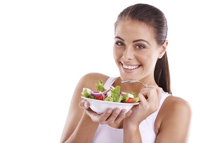 mulher sorrindo comendo salada comida