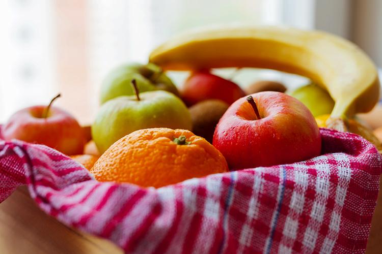 cesta de frutas com maçã, banana e laranja