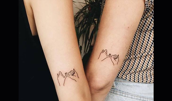 Tatuagem entre irmãs com desenho de dedos entrelaçados