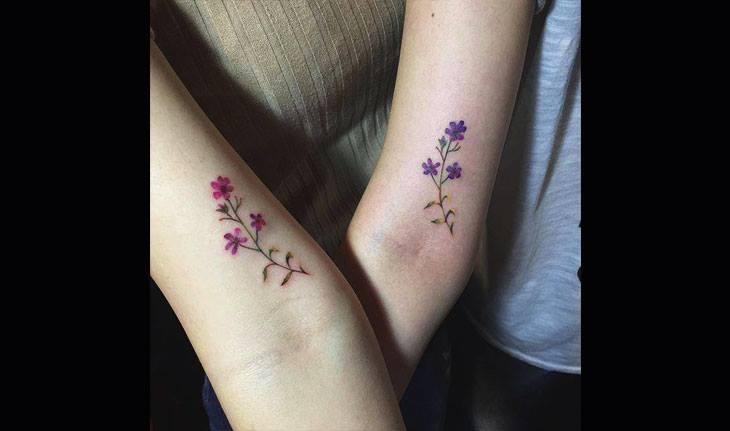 Tatuagem de ramo de flores delicada, entre irmãs