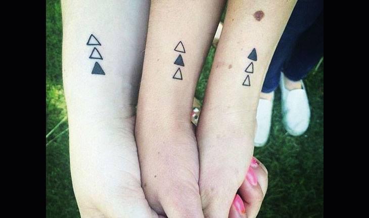 Três irmãs com tatuagens iguais no braço.