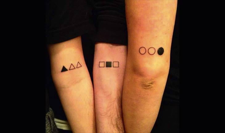 Três irmãos com tatuagens iguais no braço.