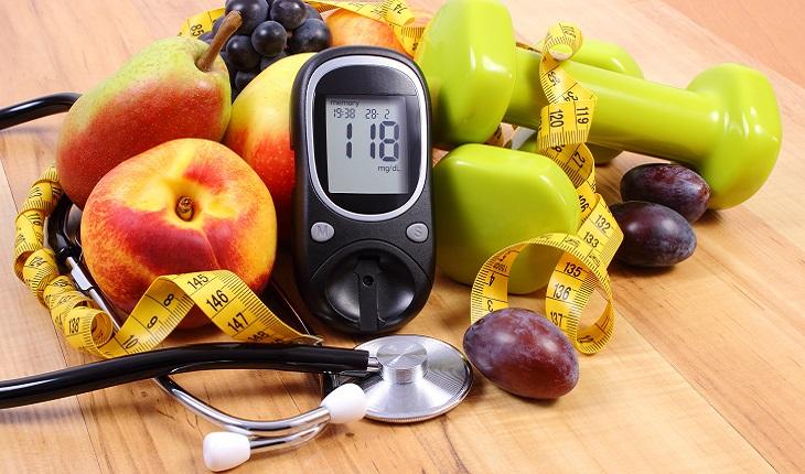 A foto mostra um monte de frutas, um medidor de insulina e um estetoscópio alertando para o risco da obesidade na terceira idade