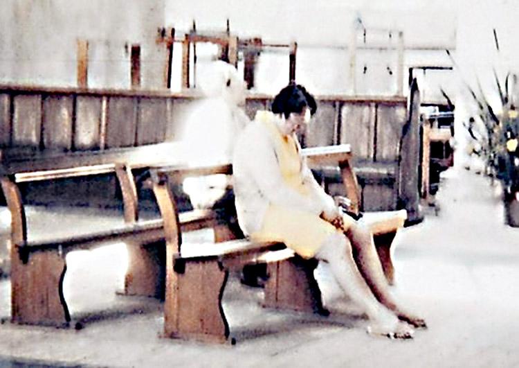 foto com uma assombração misteriosa, luz, atras de uma moça, rezando na igreja, dama de branco