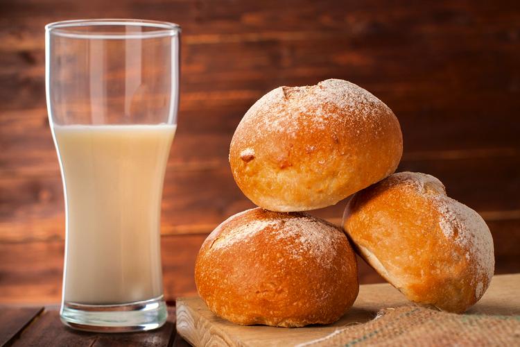 Copo de leite acompanhado de pães