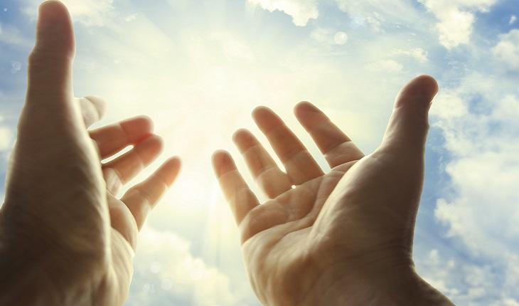 A foto mostra mãos abertas em direção a uma luz no céu simbolizando o fim do exorcismo