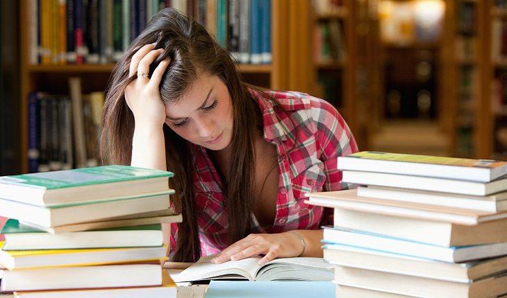 A foto mostra uma mulher estressada estudando