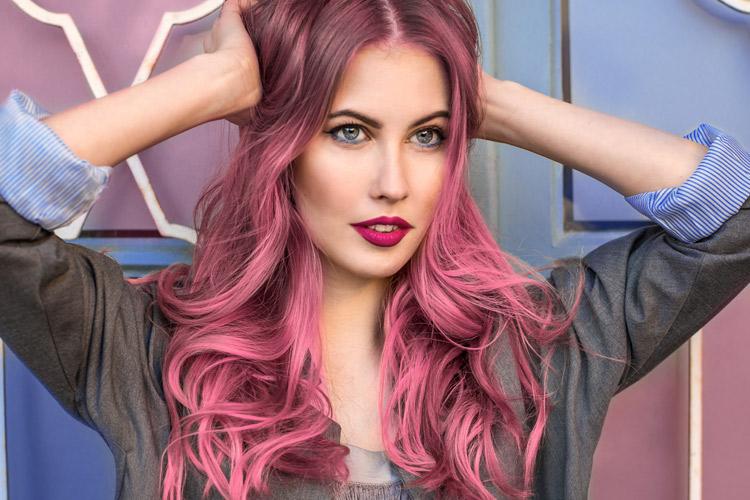 Mulher com cabelo colorido no tom rosa