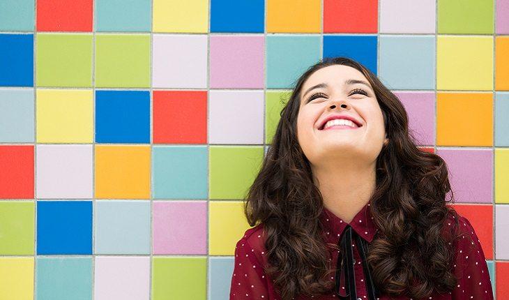 mulher sorrindo com azulejos coloridos de fundo