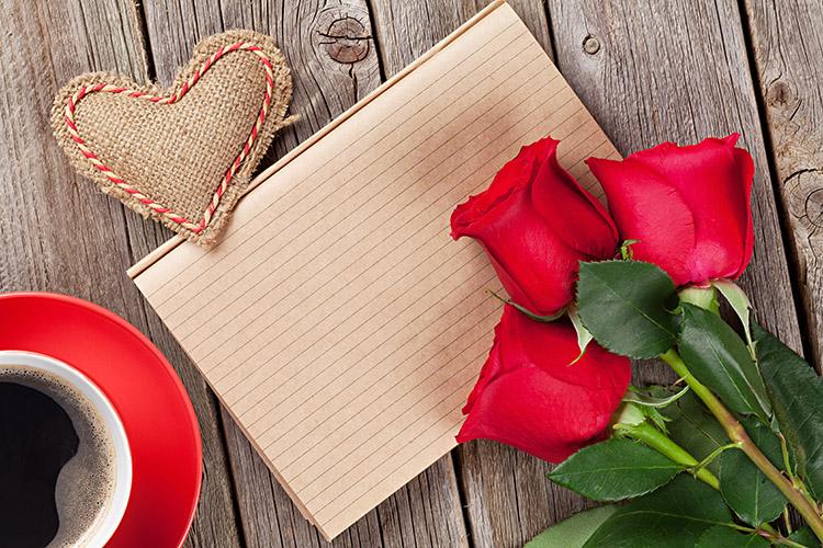 três rosas vermelhas junto com um caderno, um coração e uma xícara de café