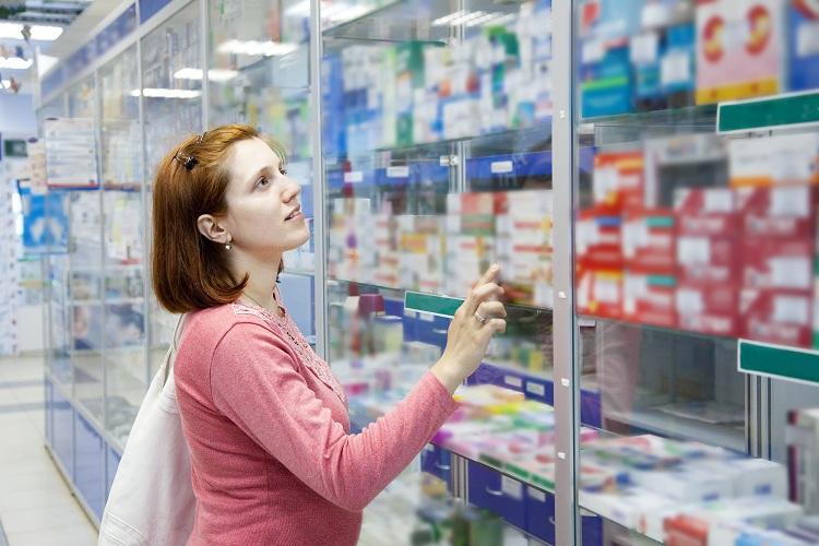 mulher escolhendo remédio na farmácia 