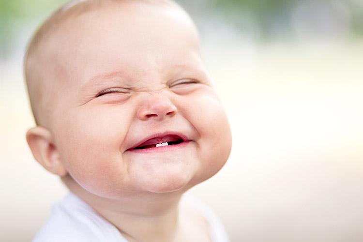 bebê sorrindo com dentinho