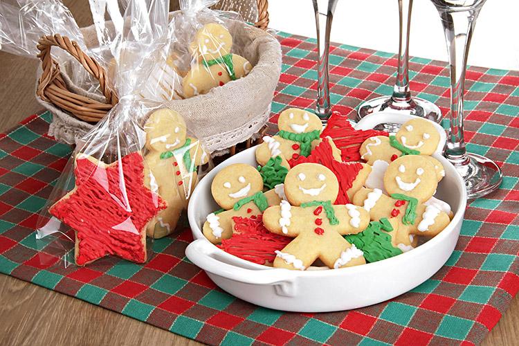 Refratário com biscoitinho natalino e com saquinho transparente com diversos biscoitinhos.