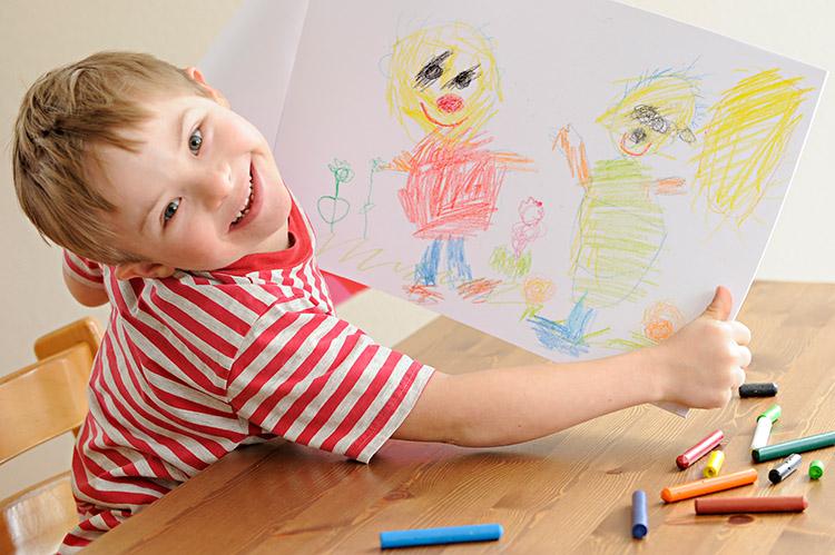 menino com síndrome de down segurando desenho feito por ele