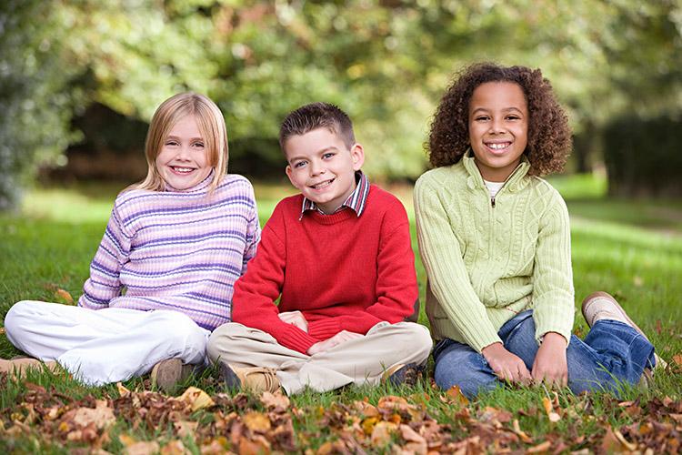 crianças sentadas na grama sorrindo